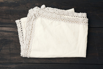 cotton beige kitchen textile towel folded on a brown wooden table from old boards
