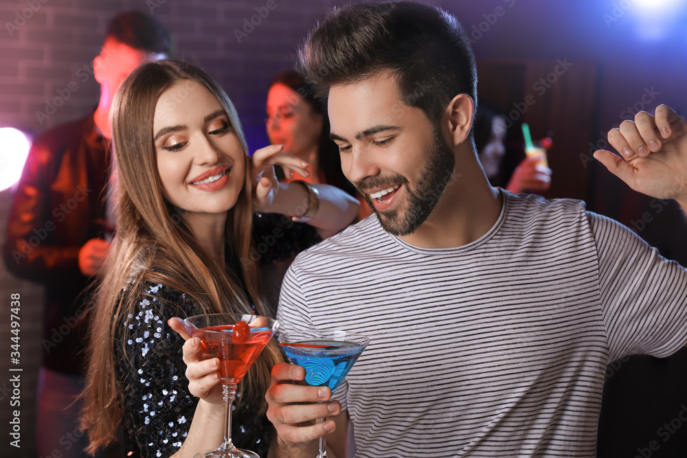 Sticker Happy young couple with cocktails in night club