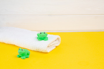 Spa and bath concept. Baby bath set and rubber frog on yellow background.