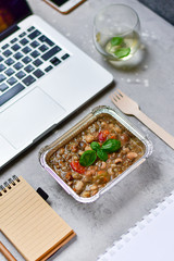 Food delivery. lunch box with a diet lunch or dinner on grey office table. Stewed beans with vegetables, takeaway lunch at the office. Top view. takeout healthy lunch. selective focus