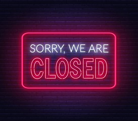 Sorry we are closed neon sign on brick wall background .