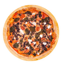 Whole pizza with cherry tomatoes, spinach, mozzarella, feta, kalamata olive and mushrooms on a round wooden platter isolated on white background with clipping path, top view