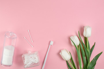 Obraz na płótnie Canvas Hygiene products and flowers on a pink background. Hygiene concept.