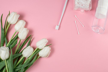  Hygiene products and flowers on a pink background. Hygiene concept.
