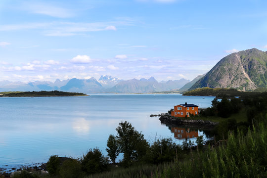 Orange house on the edge of a blue lake