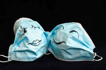 Two funny protection masks against Corona, with faces, like a man and a woman, are flirting...