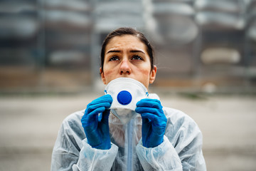 Exhausted doctor/nurse wearing coronavirus protective gear N95 mask uniform.Coronavirus Covid-19...