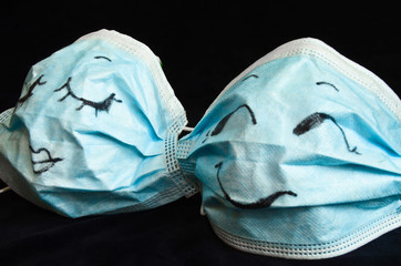 Two funny protection masks against Corona, with faces, like a man and a woman, are flirting...