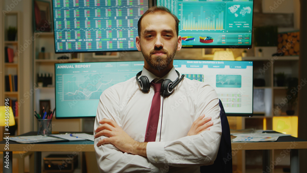 Poster bearded stock market trader looking at the camera with hands crossed.