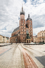 Almost empty market square in krakow during pandemic (coronavirus, covid-19) time. St Mary Church adn a sunny warm day in Krakow, Lesser Poland, Poland.