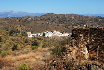 Derelict finca with the white village to the rear, Macharaviaya, Andalusia, Spain.