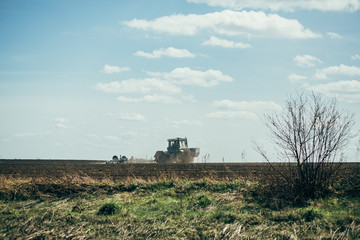 tractor performs work in the field