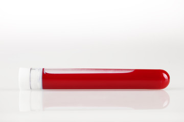 Test tube with blood and white sticker on white. Background with copy space. Coronavirus. Horizontal.
