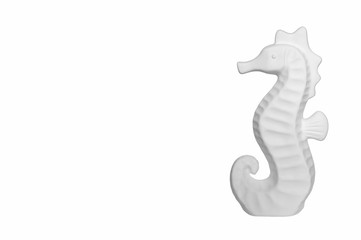 White ceramic seahorse on a white background. Space for text at the left