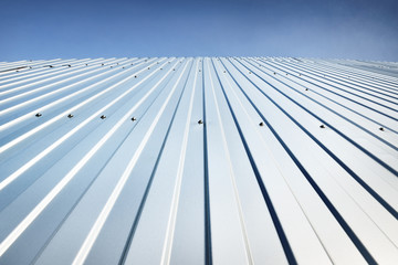Low angle view of the silvery warehouse wall. Metal siding, texture, close-up