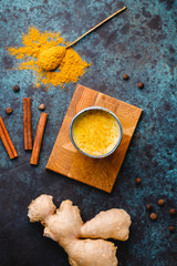 Top view of turmeric latte which is made from curcuma, ginger, cinnamon and allspice. Immune and healthcare drink.