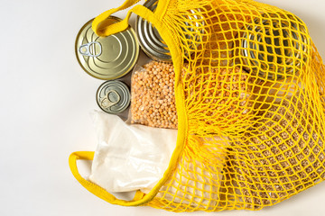 canned food and cereals in bundles in a yellow bag grid on a white background