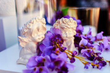 wedding decorations. details. ceramic white figurine of angels with purple flowers