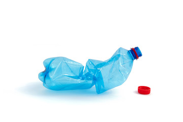 Crushed blue plastic bottle on white background.