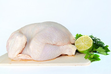fresh chilled chicken on a light background with a slice of lime and parsley