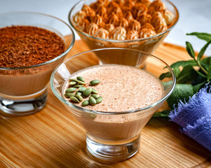 homemade dessert of yogurt and cocoa in a glass bowl on a wooden board