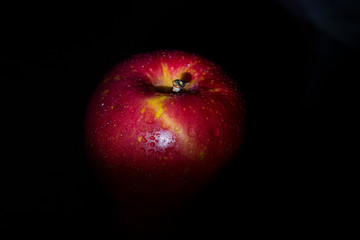 Red apple fruit in low light.