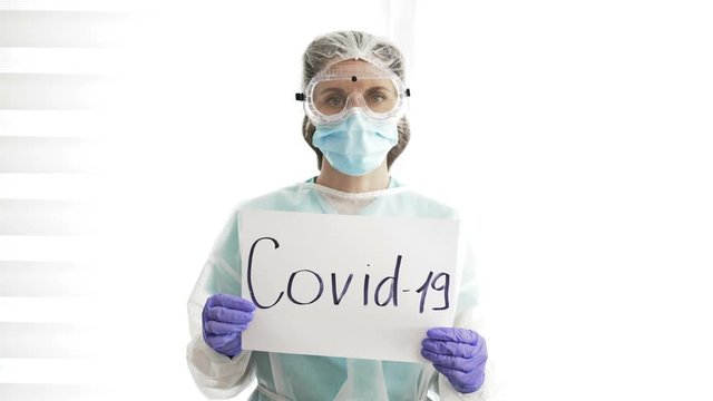 Portrait of nurse with a poster Covid-19.