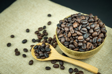 Roasted coffee beans in a wooden spoon.