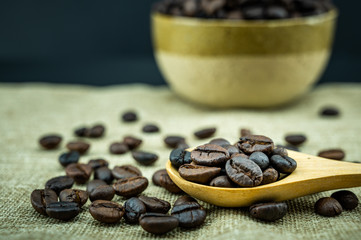 Roasted coffee beans in a wooden spoon.