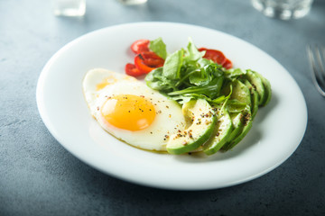 Fried egg with avocado and green salad