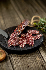Dried sausage on wooden board rosemary pepper spices wooden texture cuisine