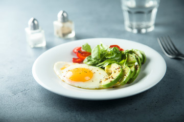 Fried egg with avocado and green salad