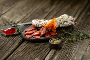 Dried sausage on wooden board with spices chili pepper wooden texture cuisine