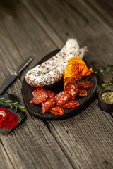 Dried sausage on wooden board with spices chili pepper wooden texture cuisine
