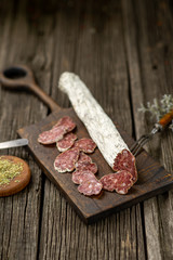 Dried sausage on wooden board with spices chili pepper wooden texture cuisine