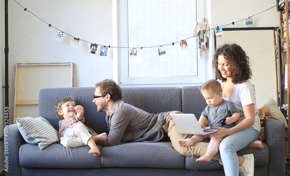 Wall mural Young beautiful happy family relaxing at home