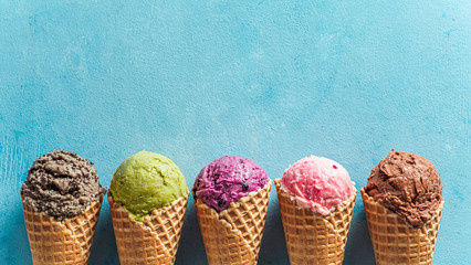 Various ice cream scoops in cones with copy space. Colorful ice cream in cones chocolate,...