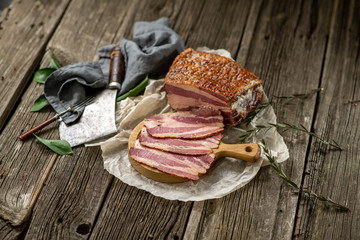 salted smoked bacon on paper with kitchen towel hatchet leaves cuisine cooking wooden texture