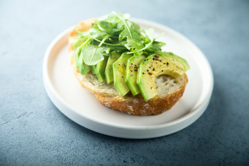 Homemade healthy avocado toast with fresh arugula