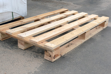 one empty wooden pallet lies on the pavement