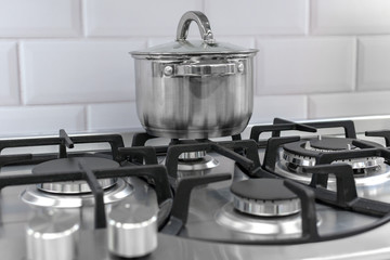 Silver pan on a modern silver gas stove in the kitchen close-up