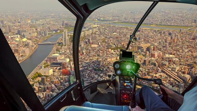 Helicopter cockpit inside the cabin flying on Tokyo downtown at sunset. Sumida district of Tokyo city of Japan in TIME LAPSE.