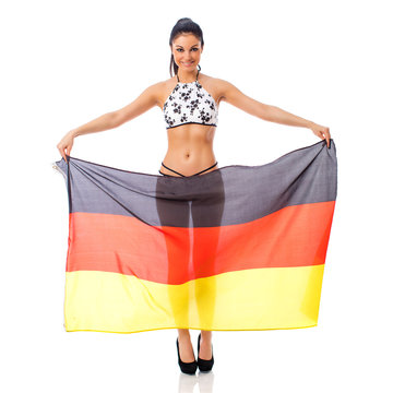 Young beautiful brunette woman in bikini holds up a clear flag of Germany