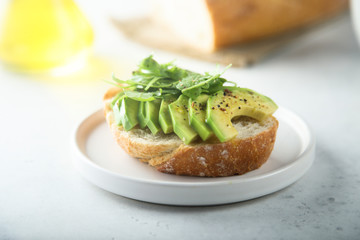 Homemade healthy avocado toast with fresh arugula