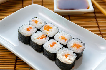 Hosomaki thin rolls, simple rolls, small rolls, with salmon. on a white plate. Syake Maki Classic roll with fresh salmon