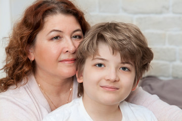 beautiful caucasian mom and son are looking at the camera