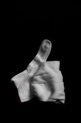 Glove made of white fabric on a black background. International signs and symbols. Youth symbols....