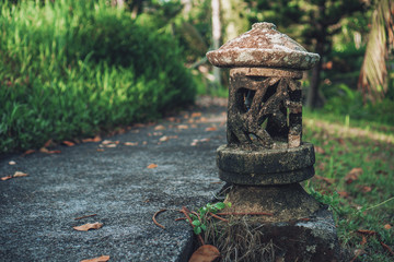 old lamp made of stone standing outside the ground