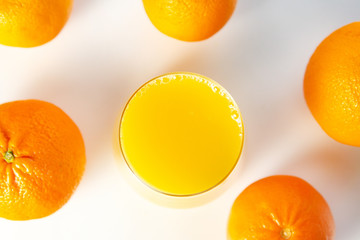 glass of orange juice and oranges fruit on a white background, selective focus