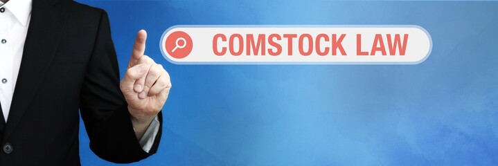 Comstock Law. Lawyer in suit points with his finger to a search box. The term Comstock Law is in...